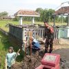 Babinsa Koramil Tipe B 0810/10 Tanjunganom Bersama Warga Gotong Royong Bangun Tembok Penahan Tanah Makam di Sambirejo