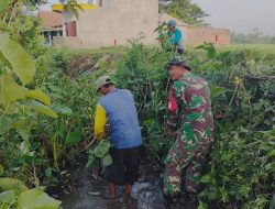 Babinsa Prambon Bersama Warga Gotong Royong Bersihkan Aliran Sungai di Desa Kurungrejo