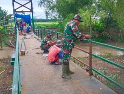 Teliti dan Penuh Dedikasi, Babinsa Cat Pagar Jembatan Perintis Garuda