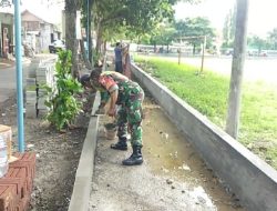 Babinsa Bantu Warga Bangun Pembatas Trotoar di Desa Pandantoyo
